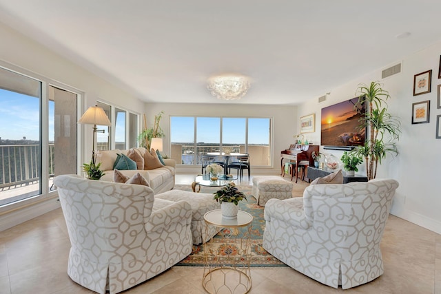 tiled living room with a healthy amount of sunlight and an inviting chandelier