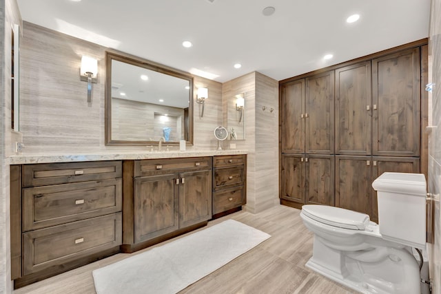 bathroom featuring tile walls, vanity, and toilet