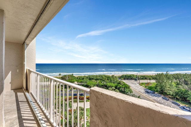 balcony featuring a water view and a beach view