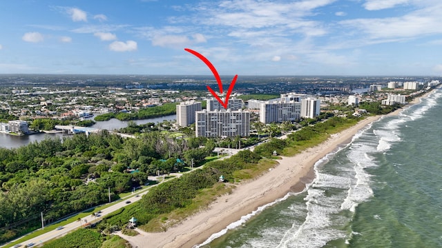 drone / aerial view featuring a water view and a view of the beach