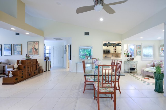 tiled dining area with high vaulted ceiling and ceiling fan