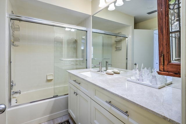 bathroom with shower / bath combination with glass door and vanity