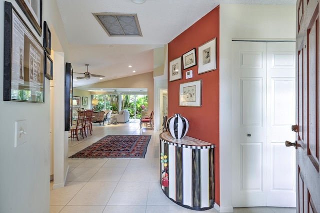 hall with light tile patterned floors and vaulted ceiling