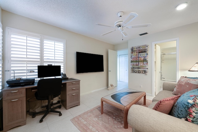 tiled home office with ceiling fan and a textured ceiling