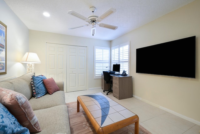 tiled living room featuring ceiling fan and a textured ceiling