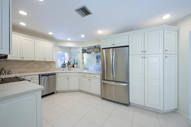 kitchen with white cabinetry, sink, tasteful backsplash, light tile patterned floors, and appliances with stainless steel finishes