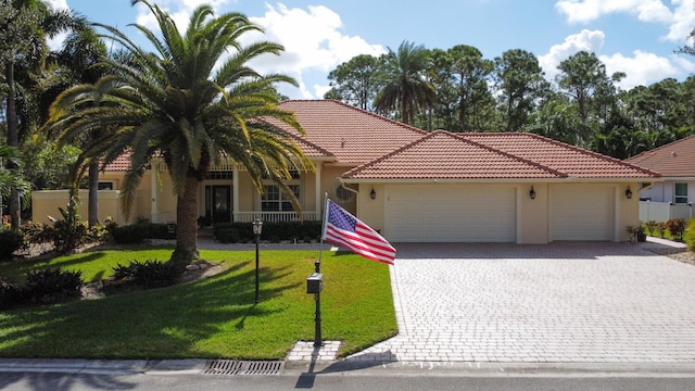 view of front facade featuring a front yard, a garage, and a porch