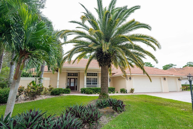 mediterranean / spanish-style house with french doors, a front yard, and a garage