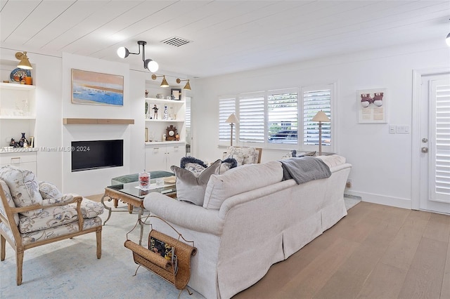 living room featuring wooden ceiling, light wood-type flooring, and built in shelves