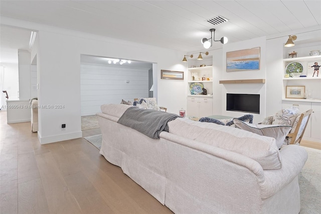 living room featuring wood ceiling, built in shelves, and light hardwood / wood-style floors