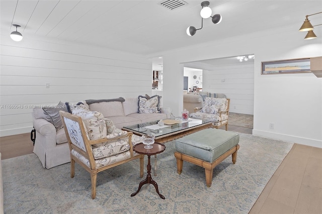 living room featuring light hardwood / wood-style flooring and wooden walls