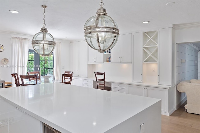 kitchen with white cabinetry, light hardwood / wood-style flooring, decorative light fixtures, and an inviting chandelier