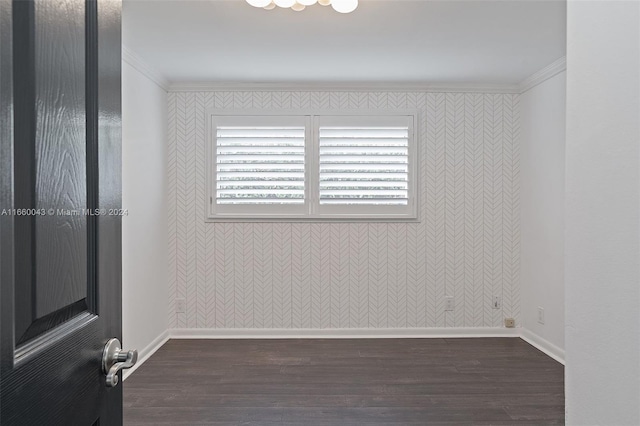 spare room featuring crown molding and dark hardwood / wood-style flooring