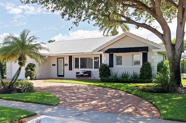 ranch-style house featuring a front lawn and a garage