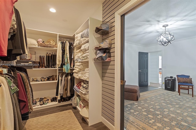 walk in closet with an inviting chandelier and hardwood / wood-style flooring