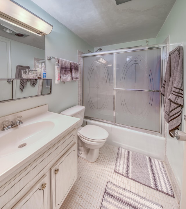 full bathroom with vanity, enclosed tub / shower combo, toilet, and tile patterned flooring