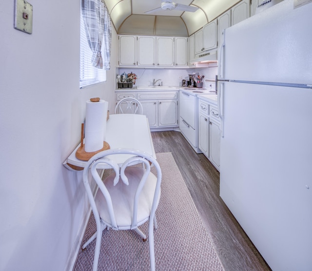 kitchen featuring white appliances, hardwood / wood-style flooring, white cabinetry, and sink