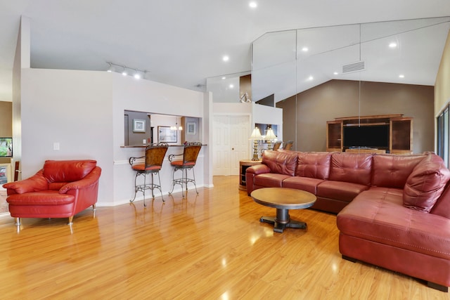 living room featuring vaulted ceiling and light wood-type flooring