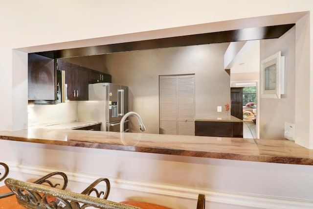 kitchen featuring dark brown cabinets, high quality fridge, and sink