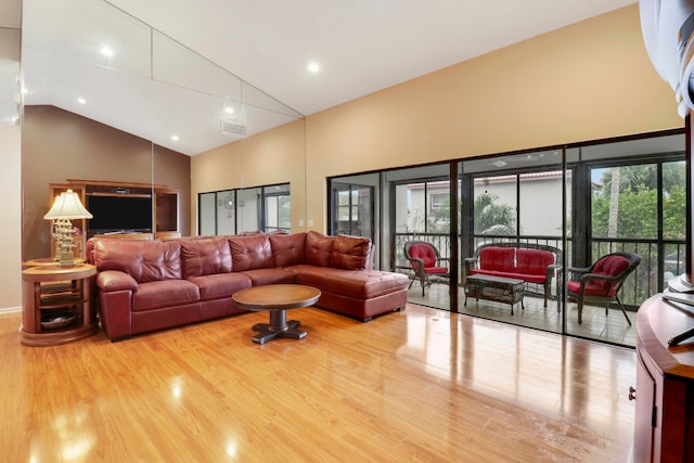 living room featuring hardwood / wood-style flooring and high vaulted ceiling