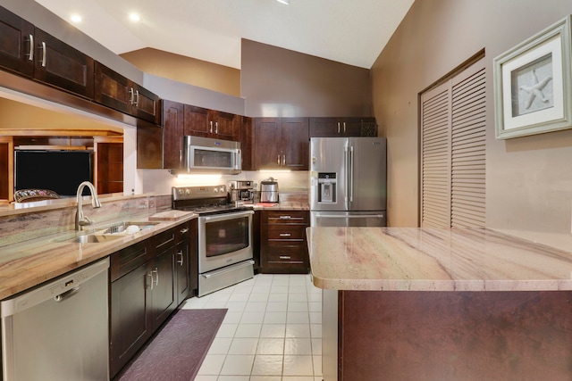 kitchen featuring sink, light tile patterned floors, vaulted ceiling, and appliances with stainless steel finishes