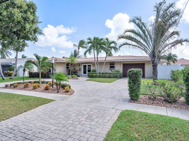 ranch-style home featuring a front lawn and a garage