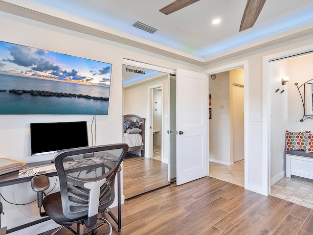 home office with wood-type flooring and ceiling fan