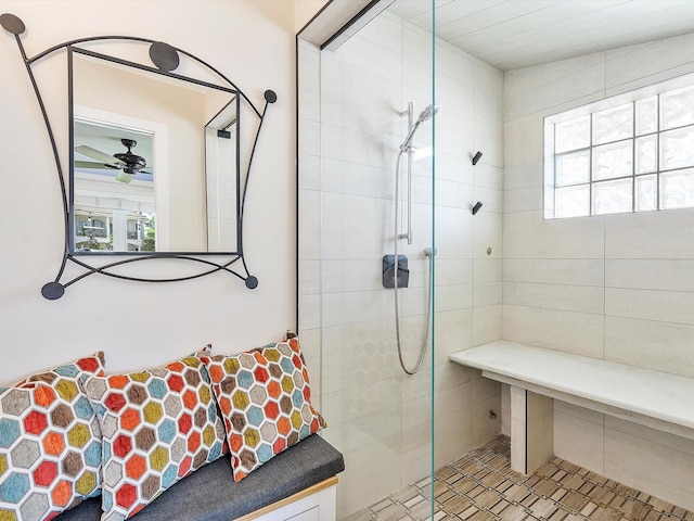 bathroom featuring a wealth of natural light, tiled shower, and ceiling fan