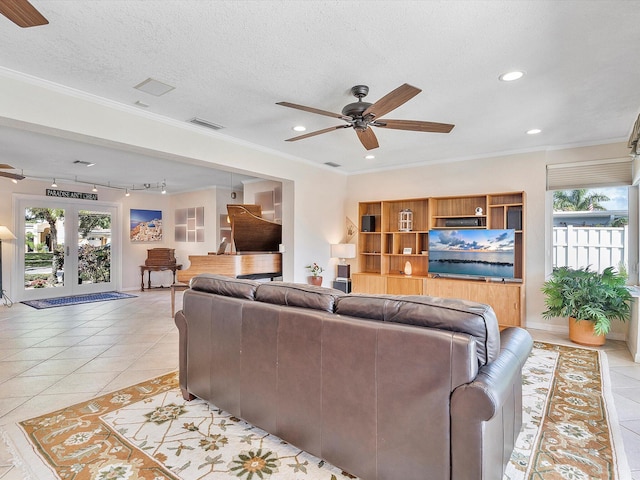 living room featuring crown molding, ceiling fan, a textured ceiling, and light tile patterned floors