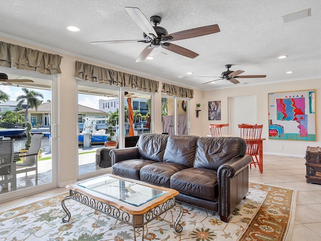 tiled living room featuring ceiling fan, a textured ceiling, and ornamental molding