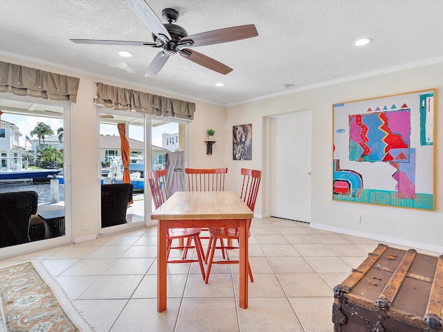 dining room featuring light tile patterned flooring, ornamental molding, a textured ceiling, and ceiling fan