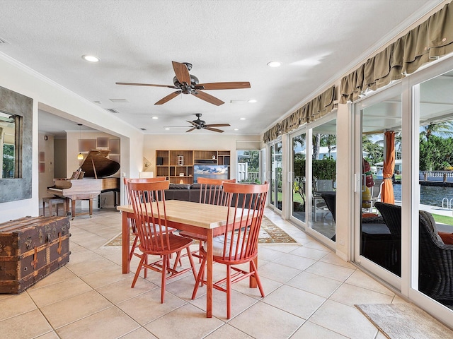 dining room with crown molding, a textured ceiling, ceiling fan, and light tile patterned floors