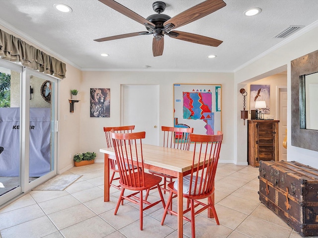 tiled dining area featuring ornamental molding, a textured ceiling, and ceiling fan