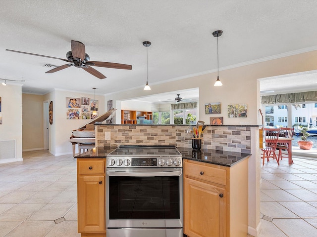 kitchen featuring backsplash, light tile patterned flooring, pendant lighting, stainless steel range, and crown molding