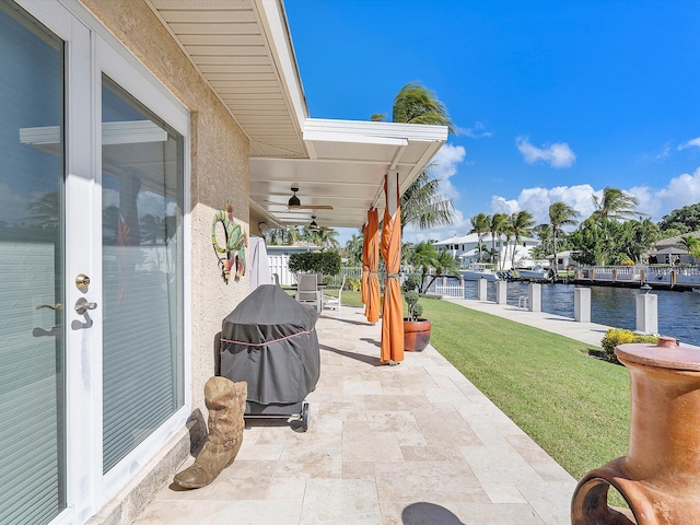 view of patio featuring a water view and ceiling fan