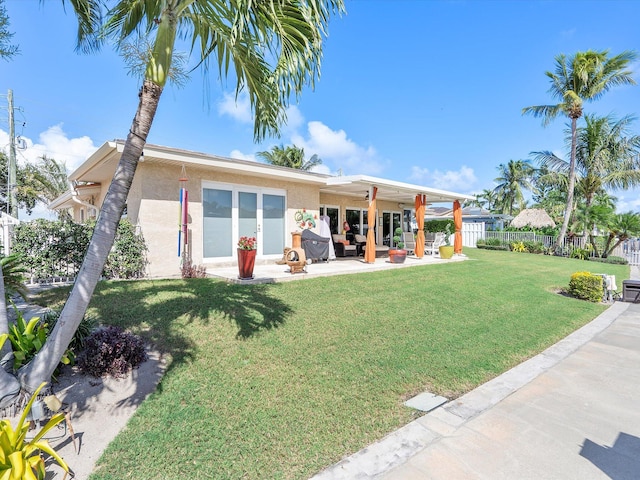 rear view of property featuring a patio and a lawn