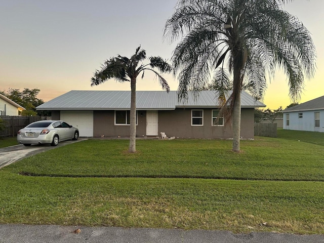 view of front of property with a yard and a garage