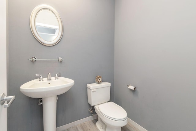 bathroom with sink, hardwood / wood-style flooring, and toilet