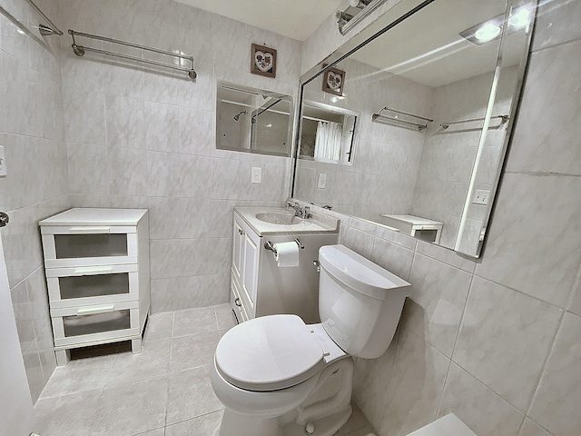 bathroom featuring vanity, toilet, and tile walls