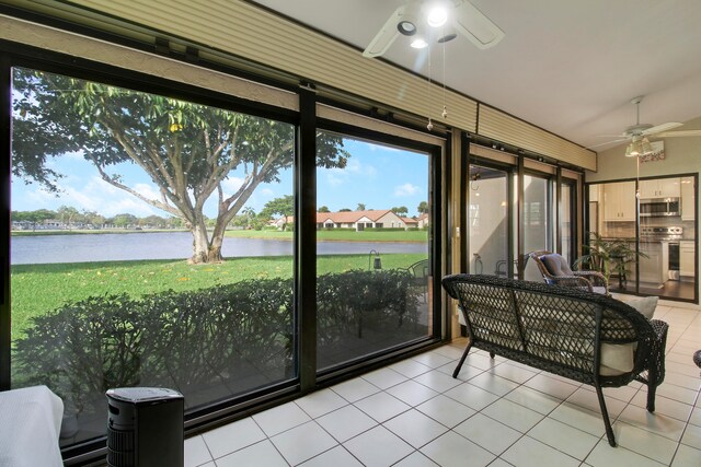 sunroom / solarium featuring a water view and ceiling fan