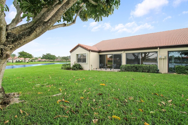 rear view of property with a yard and a water view