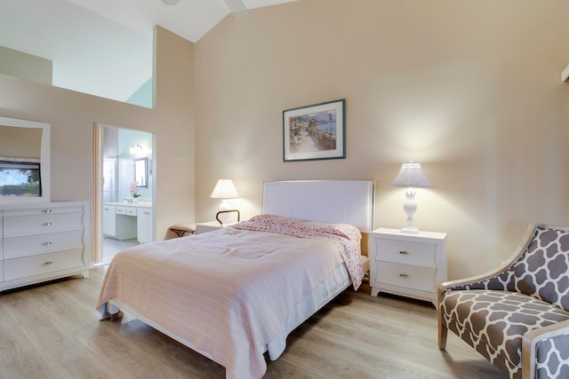 bedroom with ceiling fan, ensuite bath, light hardwood / wood-style flooring, and high vaulted ceiling