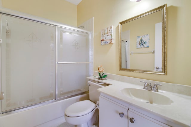 full bathroom with enclosed tub / shower combo, vanity, and toilet