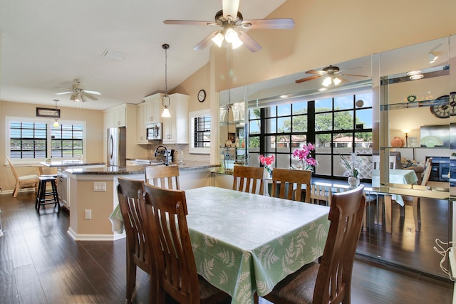 dining area featuring dark hardwood / wood-style flooring, sink, and vaulted ceiling