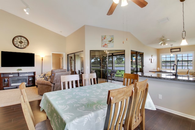 dining room featuring dark hardwood / wood-style flooring, sink, ceiling fan, and a fireplace