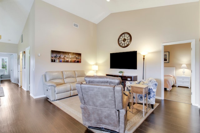 living room featuring dark wood-type flooring and high vaulted ceiling