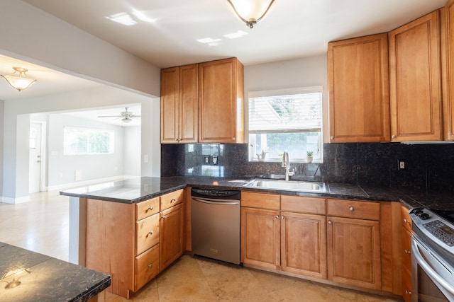 kitchen featuring kitchen peninsula, stainless steel appliances, sink, tasteful backsplash, and ceiling fan