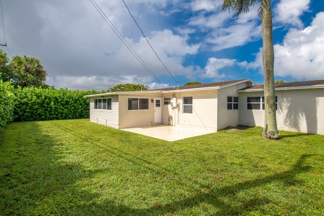 back of property featuring a patio area and a lawn