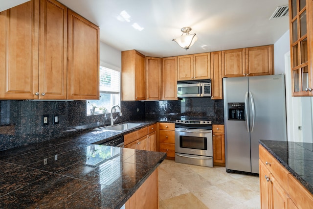 kitchen featuring stainless steel appliances, sink, and backsplash