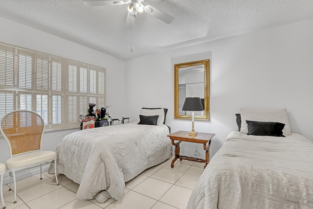 bedroom featuring ceiling fan, light tile patterned flooring, and a textured ceiling